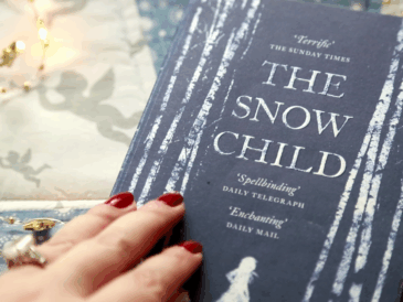 the novel The Snow Child by Eowyn Ivey as it's being opened by a woman