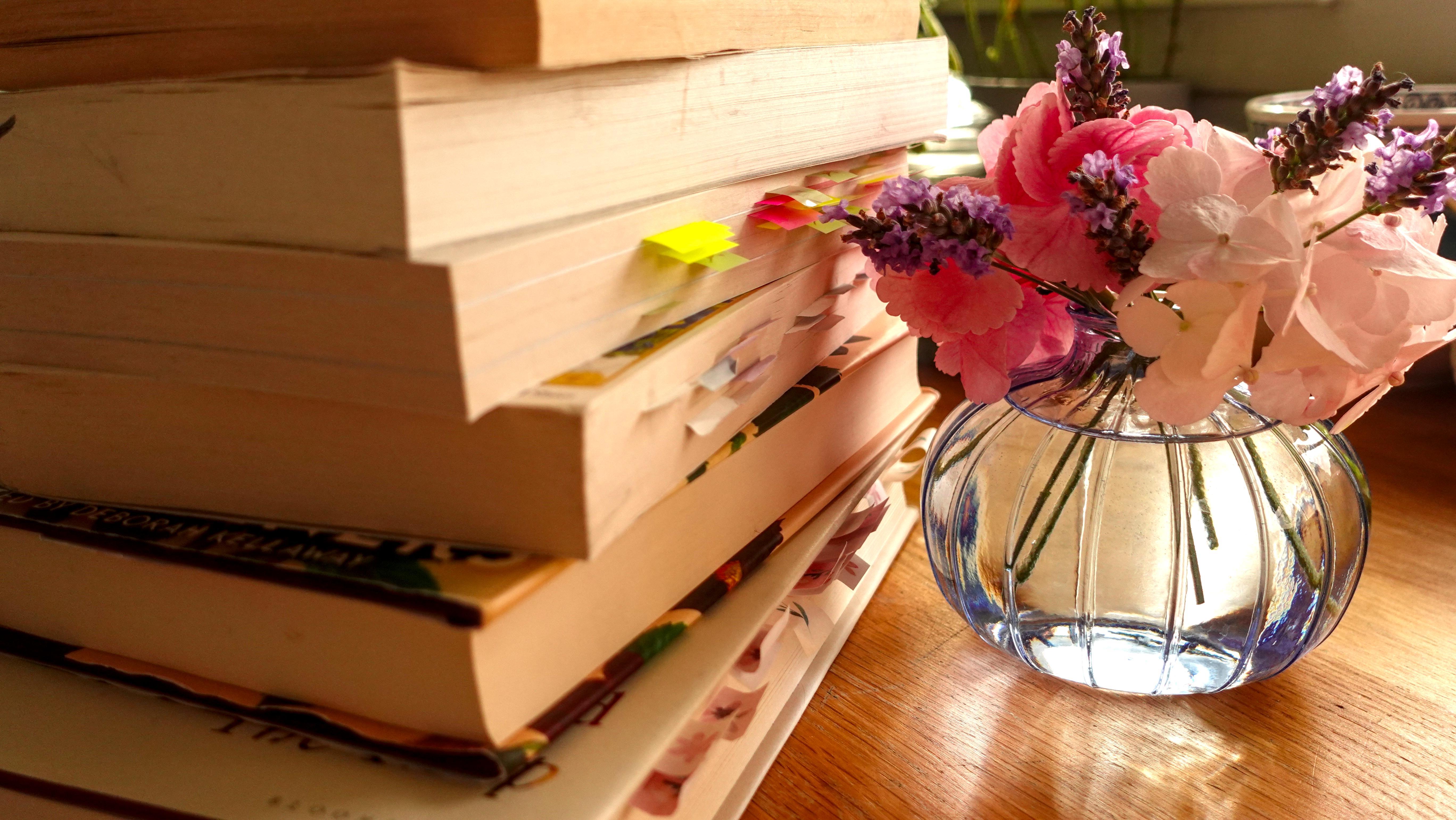 a stack of books with a floral arrangement of mini hydrangeas as lavender