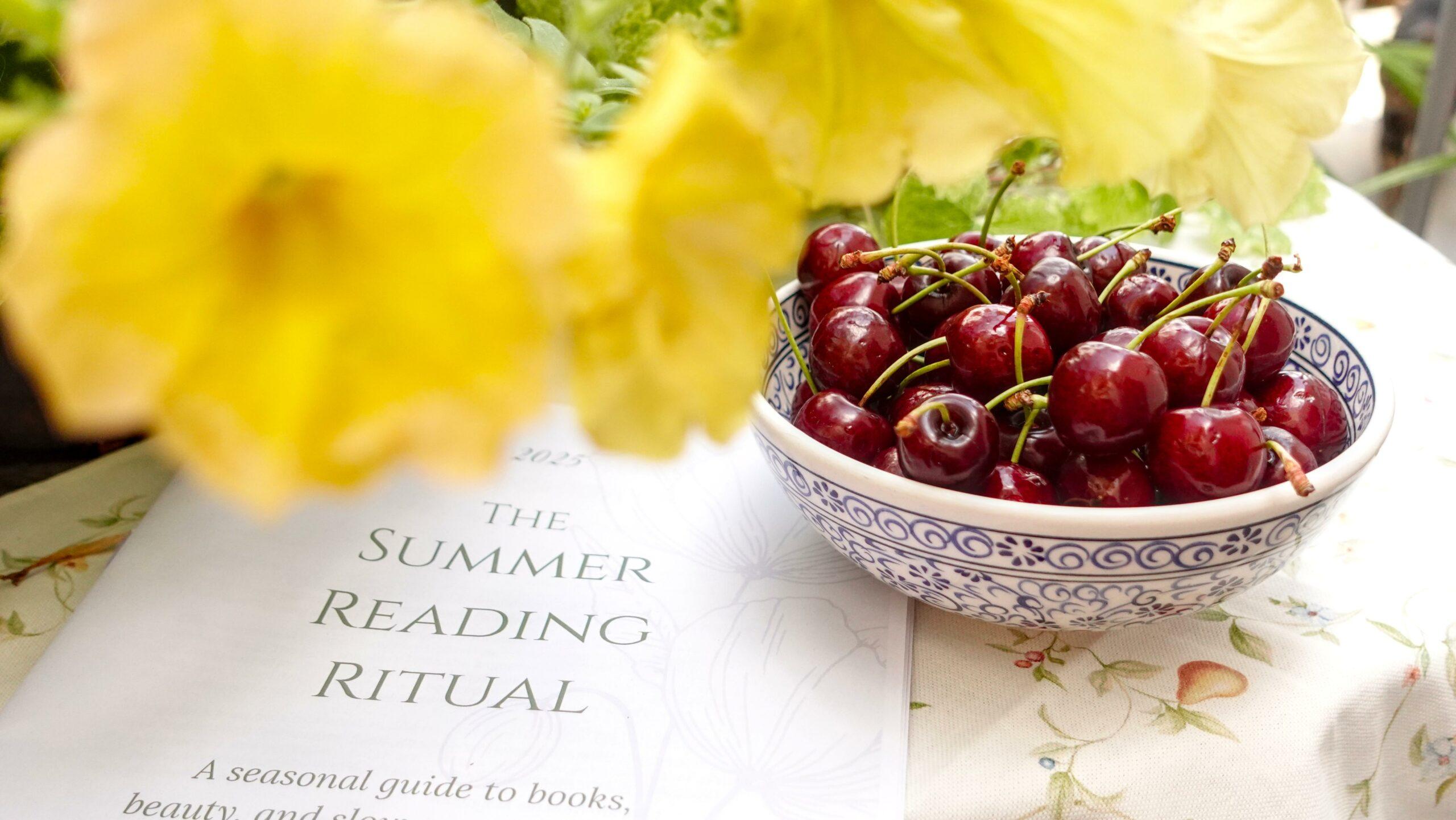 a copy of a free summer reading guide on a table with yellow flowers and a bowl of cherries