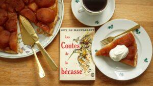 a slice of tarte tatin with crème fraîche and a volume of Maupassant's novellas