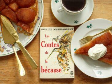 a slice of tarte tatin with crème fraîche and a volume of Maupassant's novellas