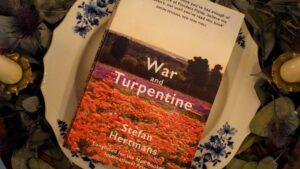 A copy of War and Turpentine by Stefan Hertmans placed on a Belgian porcelain plate, symbolizing the link between art and memory.