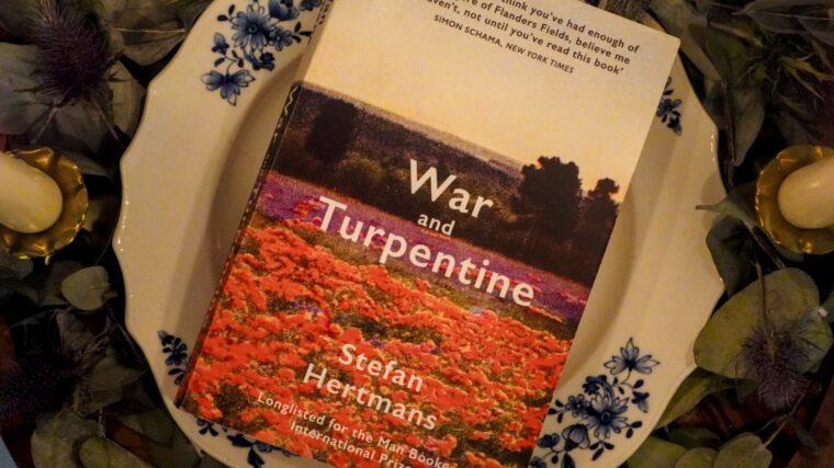 A copy of War and Turpentine by Stefan Hertmans placed on a Belgian porcelain plate, symbolizing the link between art and memory.