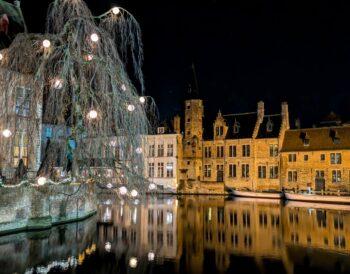 The atmospheric Rosary Quay in Bruges at night, reflecting the melancholy of Georges Rodenbach's novel Bruges-la-Morte.