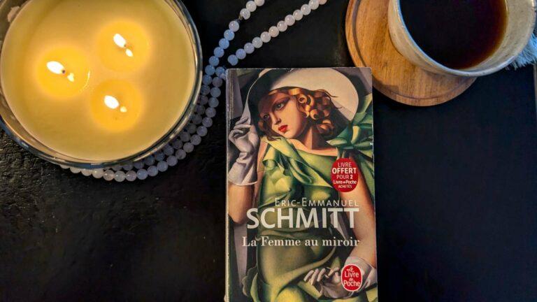 A copy of Eric-Emmanuel Schmitt's novel Three Women in a Mirror (La Femme au miroir) as a quiet reading ritual with coffee and candles.