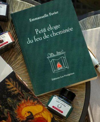 A stack of winter books including Journey into the Mind’s Eye by Lesley Blanch and Petit éloge du feu de cheminée by Emmanuelle Favier on a wooden table