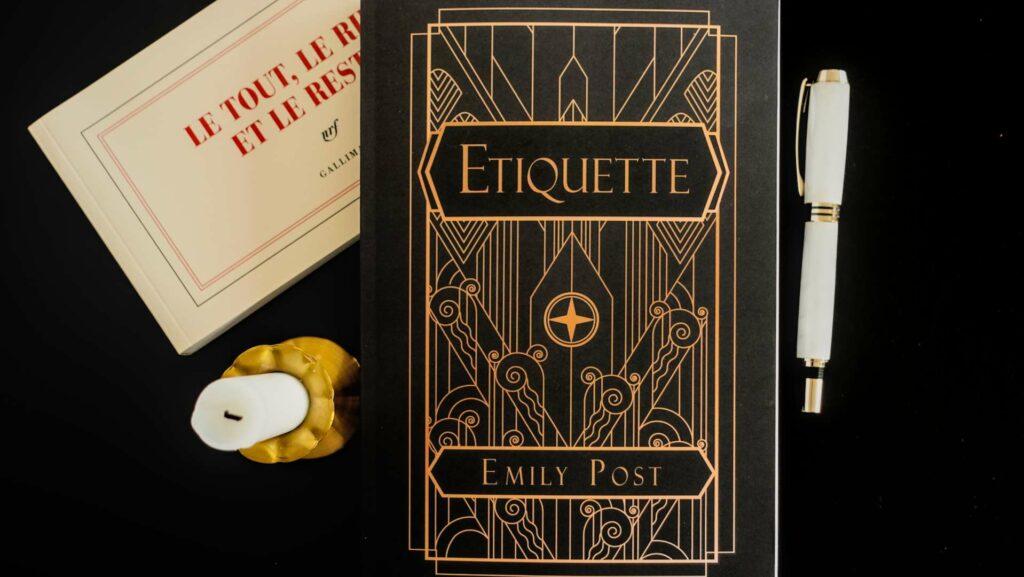Flatlay of "Etiquette in Society" by Emily Post, a classic guide to American social standards and proper conduct.