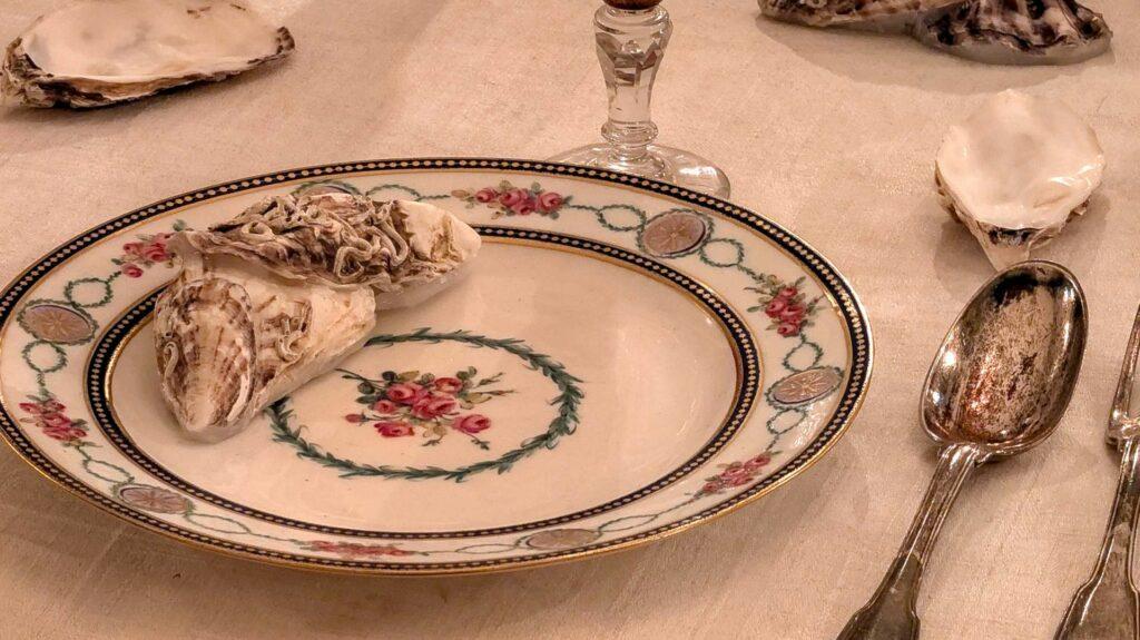 Close-up of a traditional French formal table setting and cutlery placement with Sèvres porcelain and oyster shells
