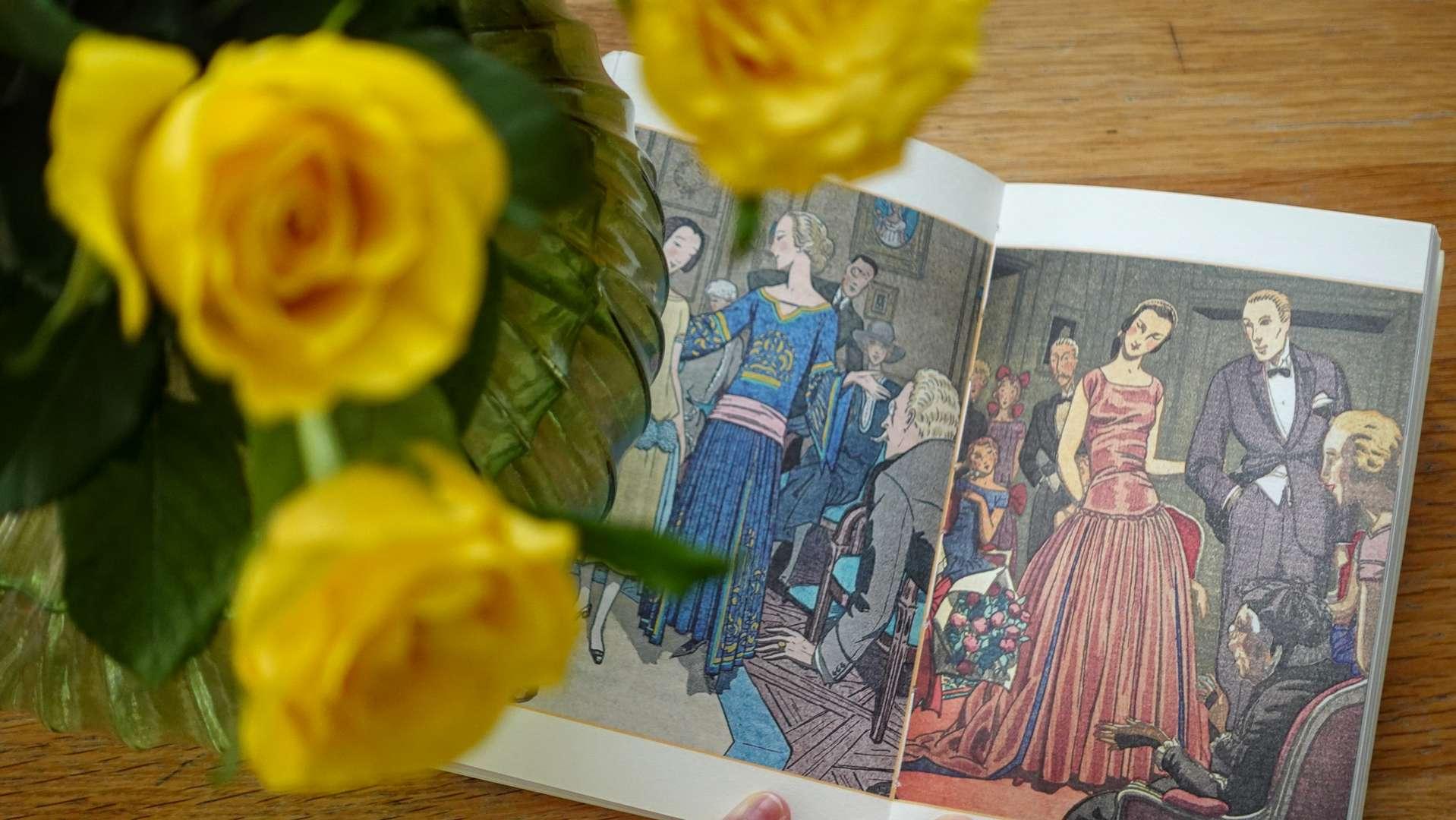 An open vintage etiquette book featuring a colorful illustration of a 1920s worldly party with guests in formal attire.