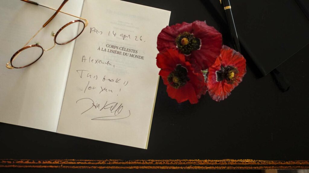 A hand-written personal inscription from author Jón Kalman Stefánsson in the front of a book, dated April 2026, alongside red poppies and gold-rimmed glasses.