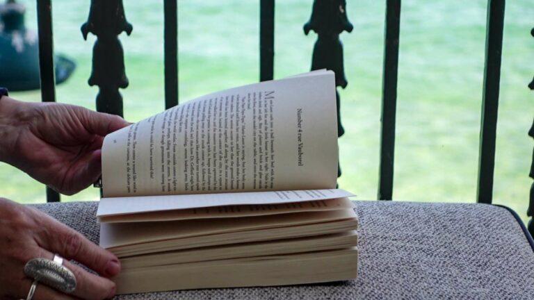 An open book resting on an armchair in a quiet, literary atmosphere