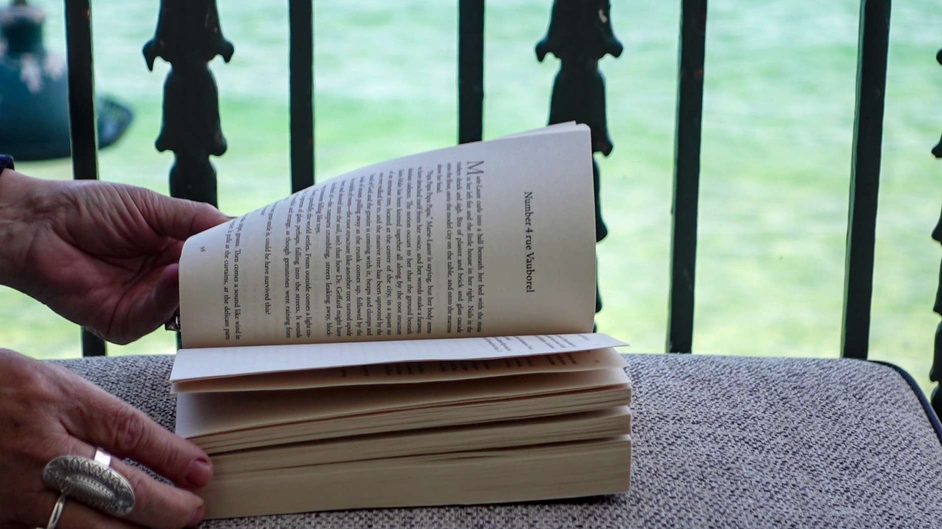 An open book resting on an armchair in a quiet, literary atmosphere